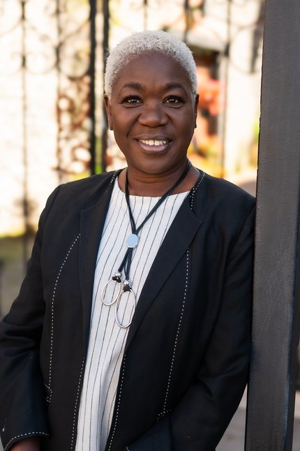 Picture of Aileen standing in front of a fireplace at Christmas.